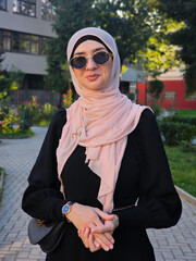 Portrait of a young happy Muslim woman in hijab in the city park.