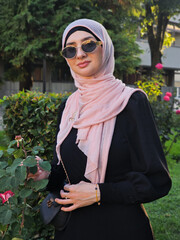 Portrait of a young fashionable Muslim woman in hijab in the city park.