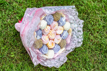 Gift set of marshmallows and sweets on green grass, close-up. Sweet food