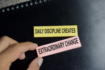 Concept of success daily discipline creates extraordinary change write on sticky notes isolated on Wooden Table.