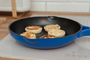 Cheesecakes are fried in a frying pan with a ruddy crust