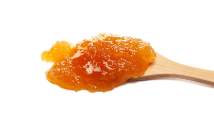 Natural crystallized honey spill in wooden spoon isolated on white, side view