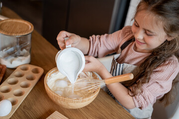 Little cute girl baking cookies in the kitchen. Homemade pastries. Cozy autumn.