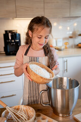 Little cute girl baking cookies in the kitchen. Homemade pastries. Cozy autumn.