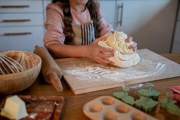 Little cute girl baking cookies in the kitchen. Homemade pastries. Cozy autumn.