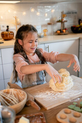 Little cute girl baking cookies in the kitchen. Homemade pastries. Cozy autumn.