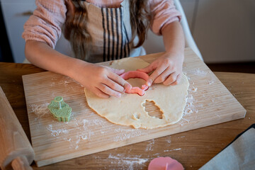 Little cute girl baking cookies in the kitchen. Homemade pastries. Cozy autumn.