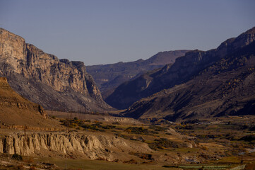 A high-mountain settlement at the foot of a rugged cliff with terracotta slopes