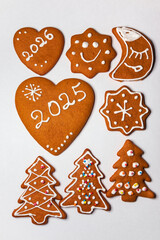 Homemade Christmas gingerbread cookies decorated and covered with white icing for the 2026 New Year. Ready-to-eat gingerbread cookies - fun patterns and shapes, a sweet holiday treat