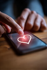 Finger tapping a glowing heart icon on a smartphone screen, symbolizing love, connection, and digital affection.