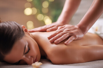 Relaxing back massage in a spa setting with a woman receiving treatment to rejuvenate and relieve tension for health and wellness.