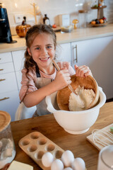 Little cute girl baking cookies in the kitchen. Homemade pastries. Cozy autumn.