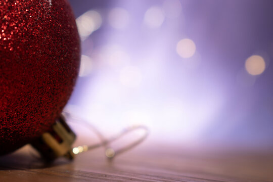 Photograph of an artificial miniature pine tree with festive blurred lights in the background.