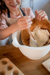 Little cute girl baking cookies in the kitchen. Homemade pastries. Cozy autumn.