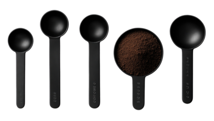 Black measuring spoons, various sizes, atop dark background.  Coffee grounds in central spoon