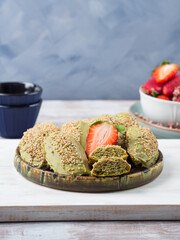 Matcha madeleine cookies with white chocolate frosting and sesame seeds