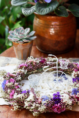 Cute floral decorations with stunning handmade wreath and other plants around the miniature white bike.