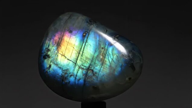 A captivating labradorite gemstone is showcased against a dark backdrop, revealing its iridescent colors and unique mineral structure, making it a top seller.