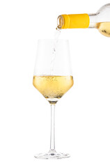 White wine being poured from a bottle into a clear wine glass, isolated on a white background.
