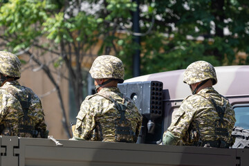Three soldiers in military truck at sunny summer day
