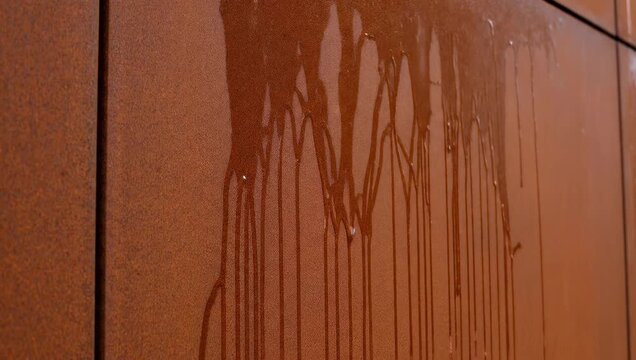 A close-up shot reveals a captivating display of dripping brown liquid cascading down a textured wall, creating an intriguing and abstract visual pattern.