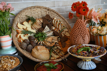 gourmet buffet table with exotic decorations, sophisticated catered event food display, vibrant salad and bread basket assortment, vertical shot of luxurious dining setup

