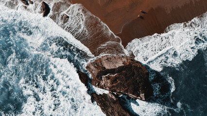 Ocean waves hitting rocky shoreline viewed from above