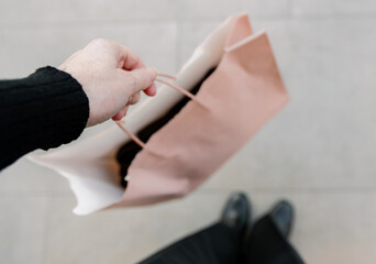 A girl holds a bag while walking through a shopping mall.