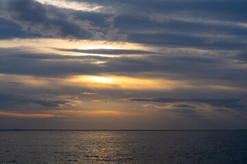 Sunset Cloudscape Ocean: Dramatic evening sky over calm sea showcasing vibrant sunset hues.