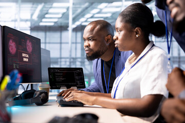 Team of programmers in server hub doing brainstorming, working to protect equipment from hacker. IT staff members facility in data center struggling to fix security breach alert