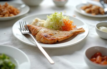 Plate with grilled fish side of salad mashed potatoes. Table setting with several plates containing food at restaurant. Delicious dish with sauce ready to eat.