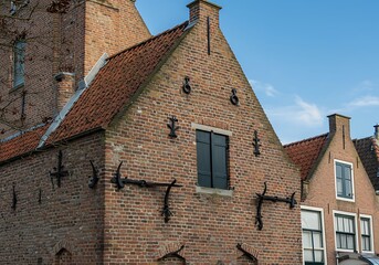 April 21, 2025 - Puttershoek-The Netherlands: Historic gable dated 1669 in the old town of Puttershoek, featuring red brickwork and wrought iron anchors typical of Dutch 17th century houses.
