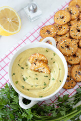 Vegan cheese sauce and crackers on white kitchen table. Top view.