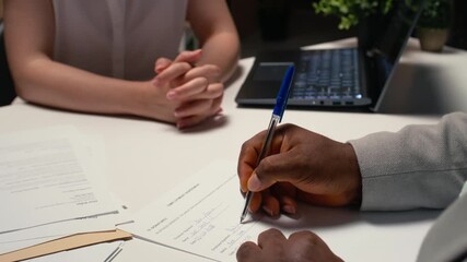 Close up of candidate signing a job contract after successful interview and HR approval, recruiter and applicant review the legal terms of employment. New professional beginning. Camera A.