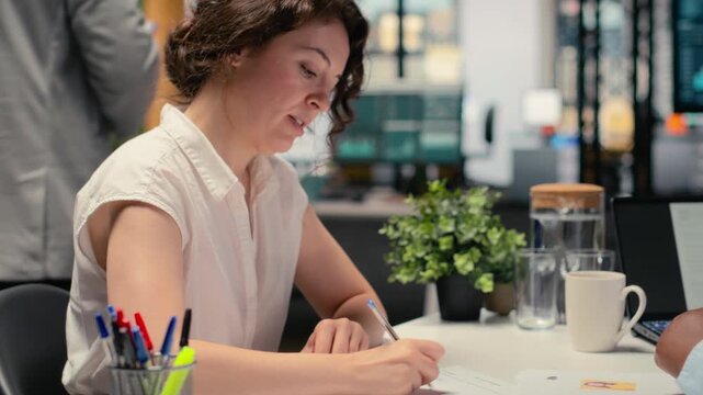 Confident woman signing a contract with human resources assistant, joining organization after legal paperwork review and agreement. Successful recruitment process for business growth. Camera B.