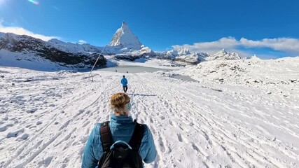 Overhead of Couple Hiking Toward Snowy Matterhorn in the Swiss Alps