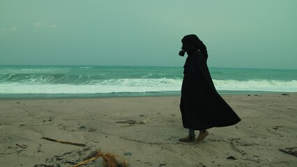 A Man In A Cloak And Gas Mask Walks On A Radiation Poisoned Beach