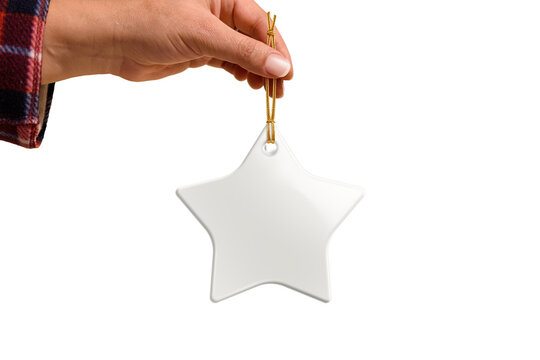 Hand holding Christmas star ceramic ornament or decoration with golden string mockup isolated on a transparent background, PNG. High resolution. Mockup, template ready for your design. - Powered by Adobe