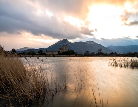 Rustic castle by a tranquil lake at sunset
