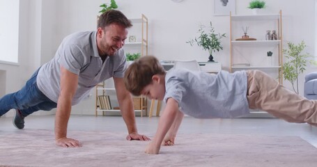 Sporty family fun, father and small son in casual clothes doing pushup pressup exercise on carpet in living room for healthy lifestyle, getting physically stronger, have fun, weekend pastime with kid  - Powered by Adobe