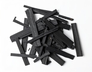 Pile of black, charred wooden sticks on white background
