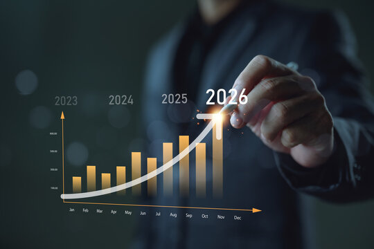 Businessman drawing upward financial growth graph to 2026, symbolizing increasing revenue, business success, and strategic planning. Concept of business forecasting and future goals.