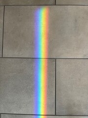 Bright rainbow light reflection on tiled floor surface