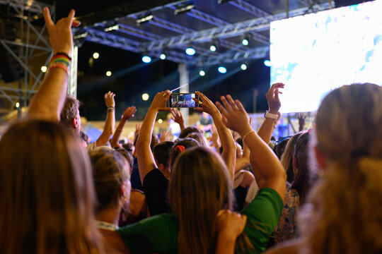 A person recording a video with a phone at the Festival of Unity and Hope at the Piazza del Popolo in Rome, as part of the Jubilee of Youth.