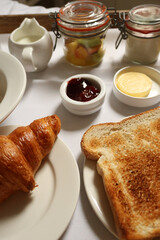 Continental breakfast items laid out on a white tablecloth, offering a diverse morning meal. Cotswolds countryside, England