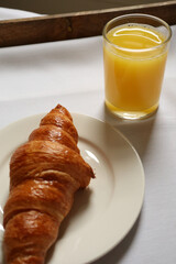 Breakfast tray with fresh croissant and invigorating orange juice. Cotswolds countryside, England