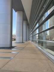 Fototapeta premium Modern exterior with tall columns, reflective glass walls, and minimalist architecture design.
