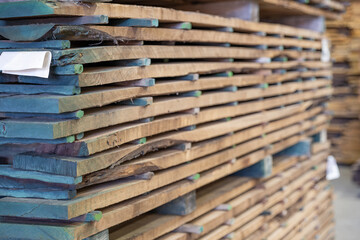 Wooden planks neatly stacked in a workshop showcasing craftsmanship and raw material for construction or art projects