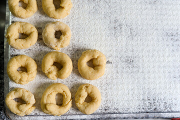 Homemade donuts on floured tray ready for cooking