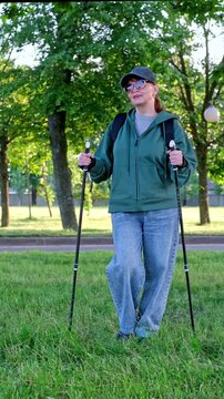 Nordic walking. A woman exercises in a park. video. 4k